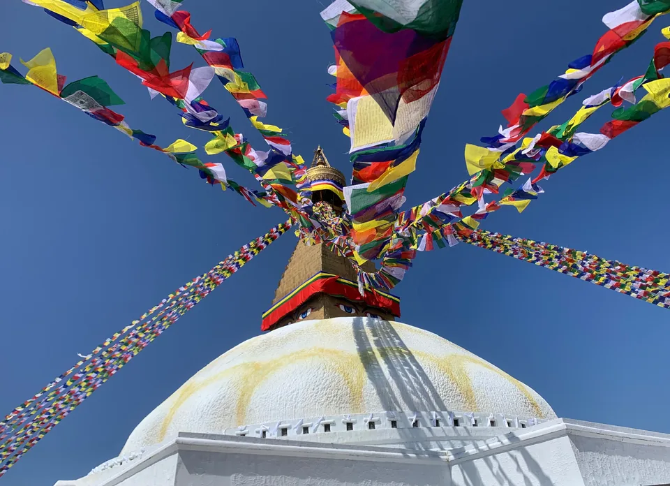 Colourful prayer flags stretch from the golden spire above Boudhanath’s white dome.